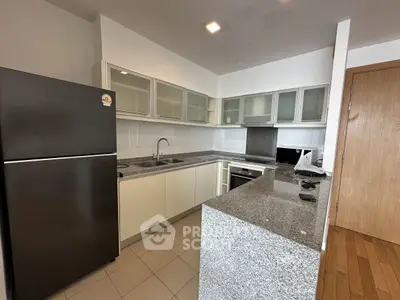Modern kitchen with sleek granite countertops and stainless steel appliances.