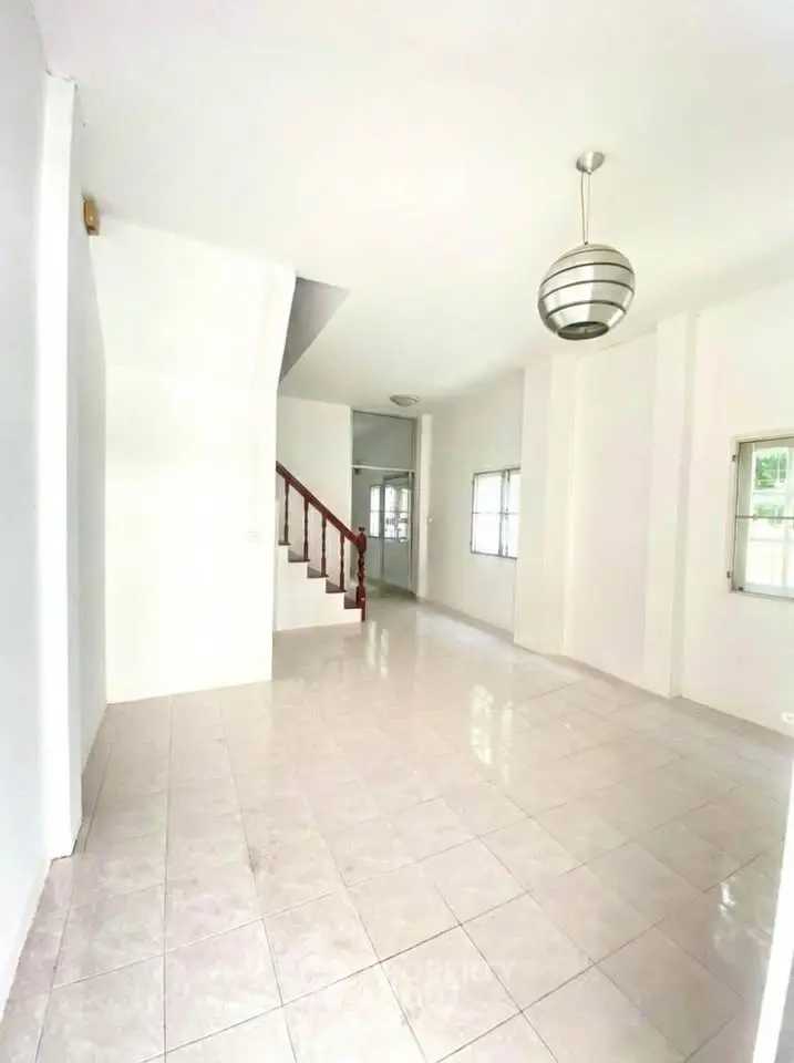 Spacious bright living room with modern staircase and elegant lighting