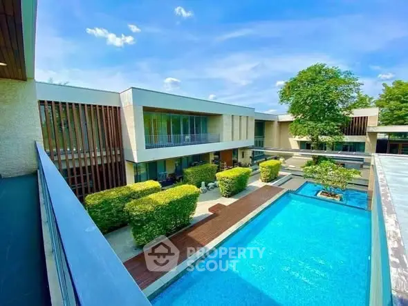 Luxurious modern home with stunning pool and lush greenery, perfect for relaxation and entertainment.