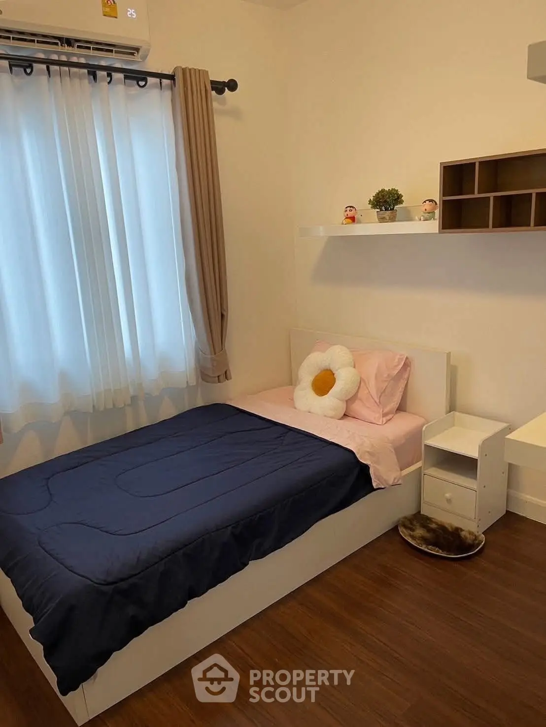 Cozy bedroom with single bed, stylish decor, and wooden flooring.