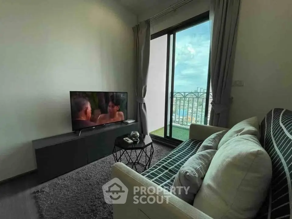 Cozy living room with modern decor and balcony view in urban apartment.