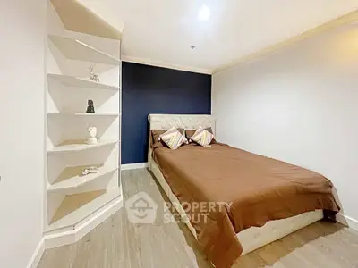 Cozy bedroom with modern decor and stylish shelving, perfect for relaxation and comfort.