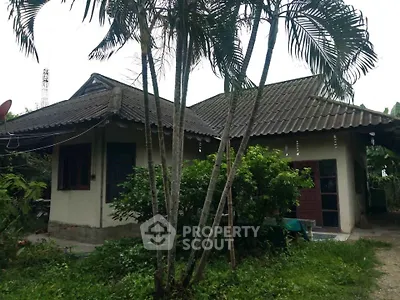 Charming rustic house with lush greenery and traditional roof design, perfect for nature lovers seeking tranquility.