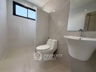 Modern bathroom with sleek fixtures and large window for natural light.