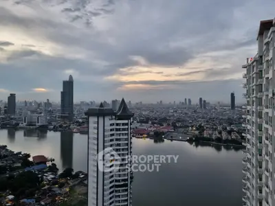 Stunning cityscape view from high-rise apartment overlooking river and skyline at dusk