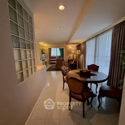Elegant dining area with classic furniture and open layout leading to cozy living room.