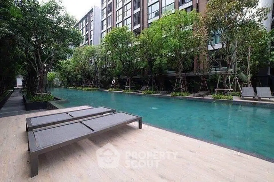 Luxurious condominium with serene poolside and lush greenery, perfect for relaxation and leisure.