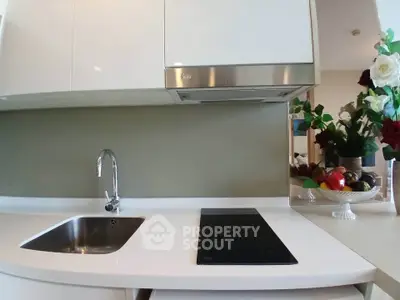 Modern kitchen with sleek white cabinets and induction cooktop