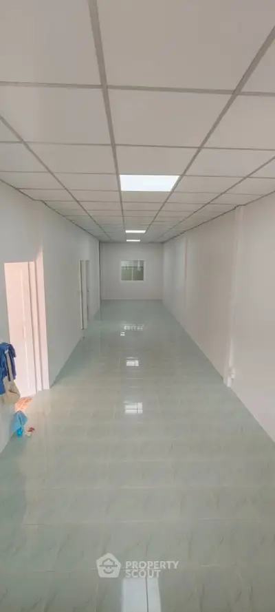 Spacious empty room with tiled floor and white walls, ideal for customization.