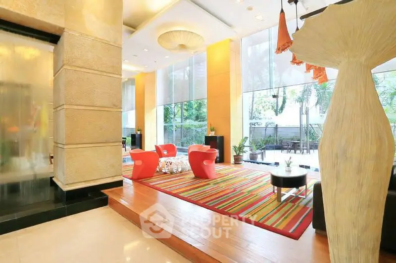 Luxurious modern lobby with vibrant decor and large windows offering garden views.