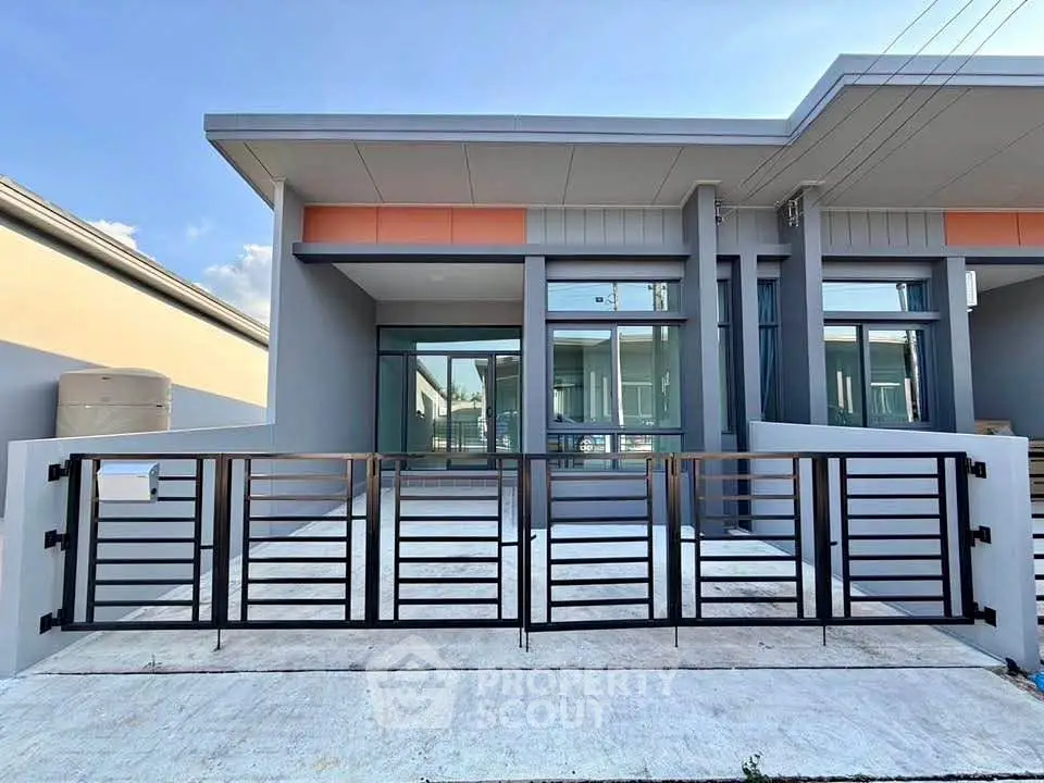 Modern single-story home with sleek metal gate and large windows
