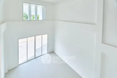 Spacious white interior with large windows and sliding doors, perfect for natural light.