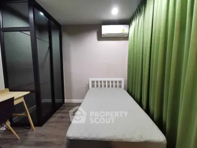Cozy bedroom with single bed, study desk, and modern glass wardrobe, perfect for a minimalist lifestyle.