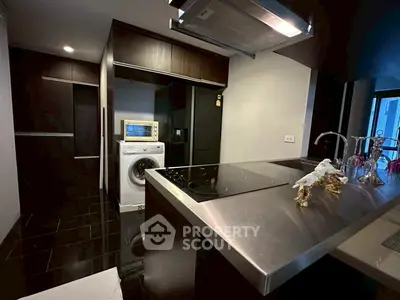Modern kitchen with sleek appliances and washing machine in stylish apartment
