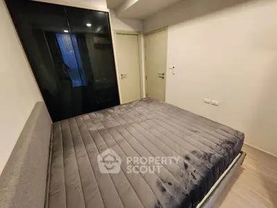 Modern bedroom with sleek design and cozy ambiance, featuring a plush bed and minimalist decor.