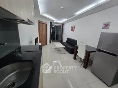 Modern open-layout living room with sleek kitchen and stylish furnishings in a contemporary apartment.