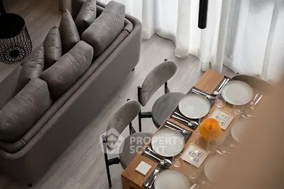 Modern living room with elegant dining setup and cozy sofa, perfect for stylish gatherings.