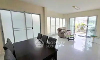 Spacious living room with large windows and modern furniture, perfect for family gatherings.