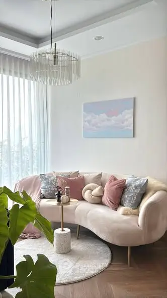 Elegant living room with chic decor, featuring a plush sofa, stylish chandelier, and large window for natural light.