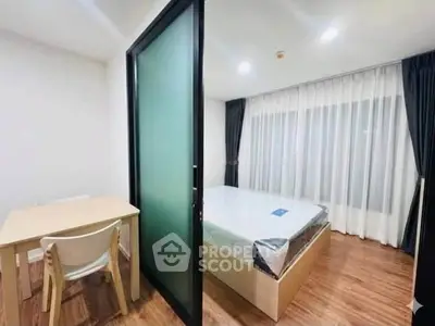 Modern bedroom with frosted glass sliding door and wooden flooring