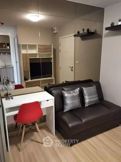 Modern living room with sleek furniture and mirrored wall enhancing space