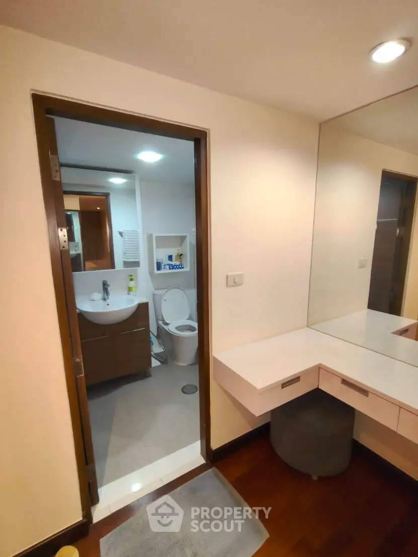 Modern bathroom with sleek vanity and large mirror in a contemporary apartment.