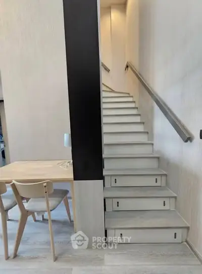 Modern interior with sleek staircase and minimalist dining area in a stylish home.