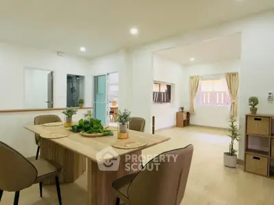 Spacious open-plan dining and living area with modern decor and natural light.
