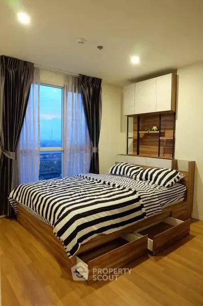 Modern bedroom with stylish wooden bed and large window offering scenic views.