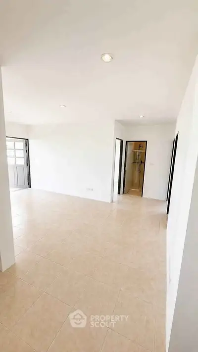 Spacious open-plan living area with tiled flooring and ample natural light, perfect for modern living.