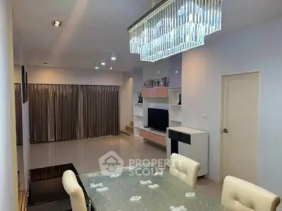 Spacious modern living room with elegant chandelier and stylish dining area.