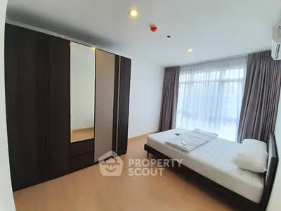 Spacious bedroom with large wardrobe and natural light