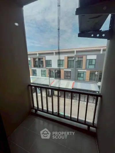 Charming balcony with street view in modern townhouse, perfect for relaxation and enjoying the neighborhood.