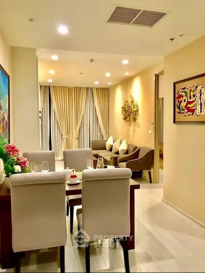Elegant living room with modern decor and dining area, featuring stylish furniture and ambient lighting.