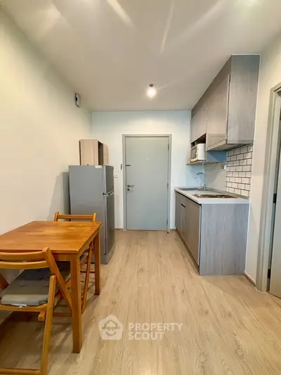 Modern kitchen with wooden dining set and sleek appliances in cozy apartment