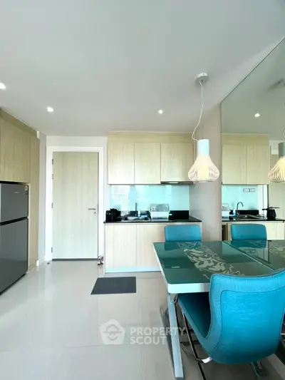 Modern kitchen with sleek design, glass dining table, and stylish lighting in a contemporary apartment.