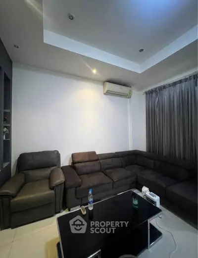 Modern living room with sleek black furniture and ambient lighting