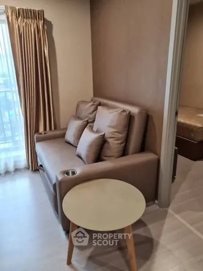 Cozy living room with plush sofa and natural light, perfect for relaxation.