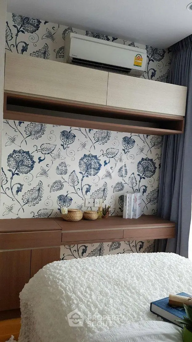 Chic bedroom with floral wallpaper and modern air conditioning unit, perfect for a cozy retreat.