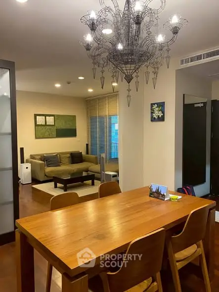 Elegant living room with chandelier and wooden dining set, perfect for modern family gatherings.