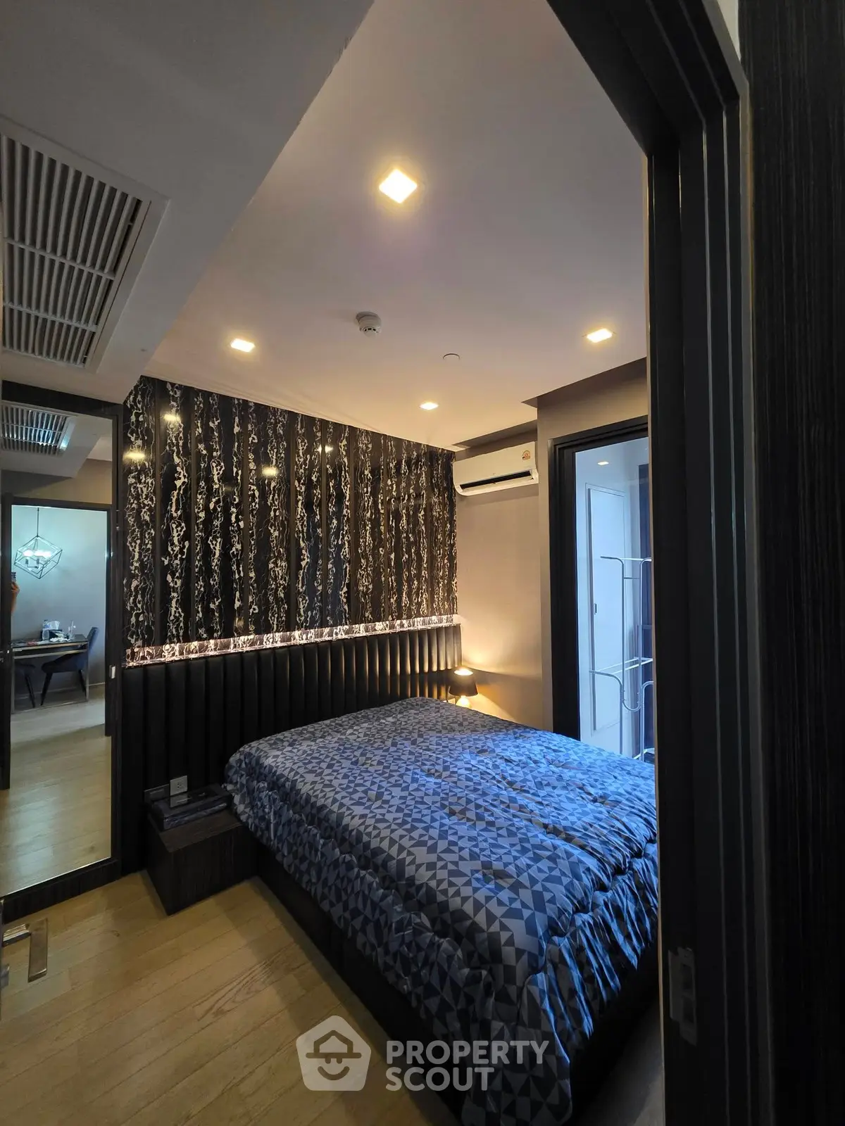 Modern bedroom with stylish decor and cozy ambiance, featuring a comfortable bed and elegant lighting.