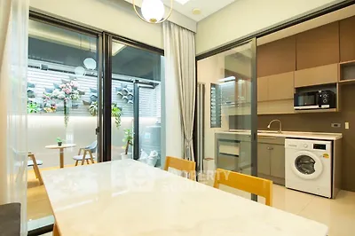 Modern kitchen with washing machine and open layout, featuring a bright dining area and outdoor view.