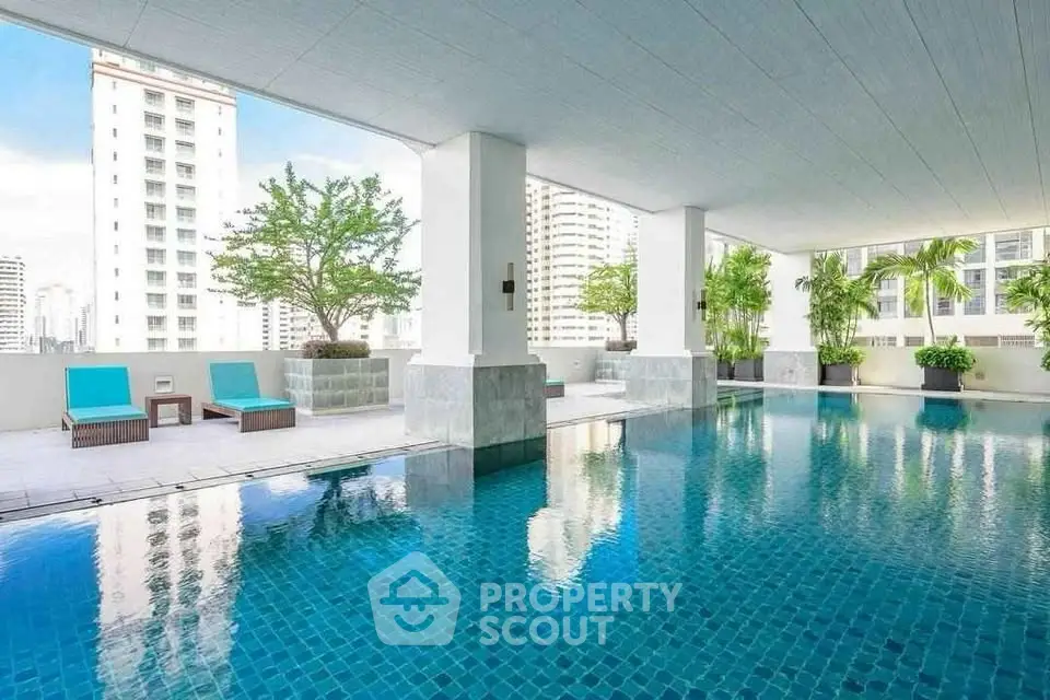 Luxurious rooftop pool with city views and modern lounge chairs in a high-rise building.