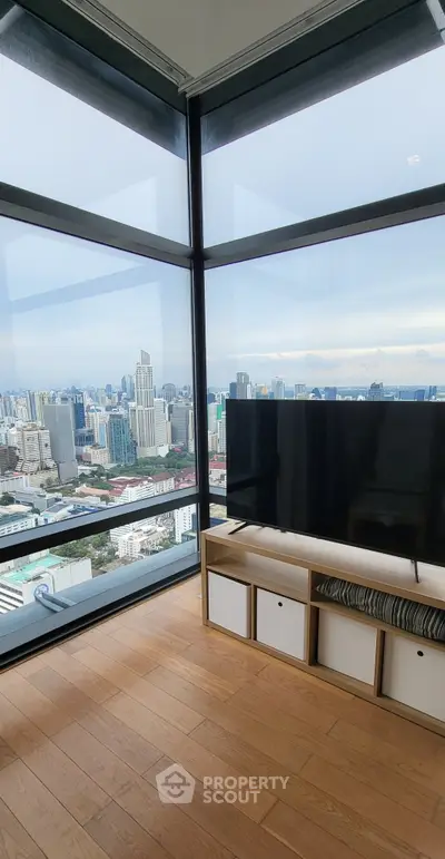 Stunning city view from a modern high-rise apartment with floor-to-ceiling windows.