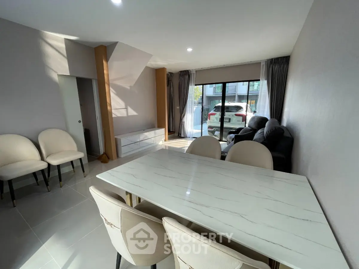 Spacious modern living room with elegant dining area and large window view.