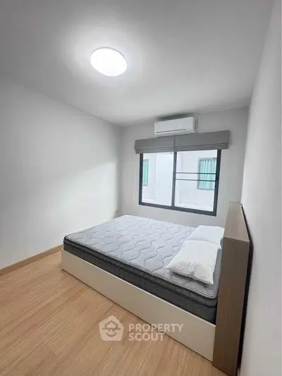 Modern minimalist bedroom with natural light and wooden flooring