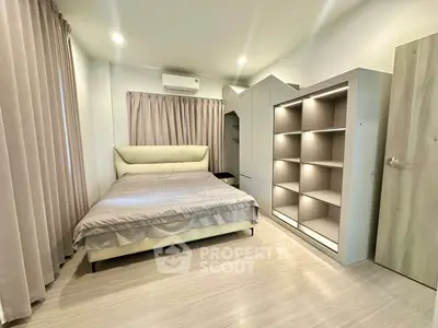 Modern bedroom with stylish bed and built-in shelving, featuring soft lighting and neutral tones.