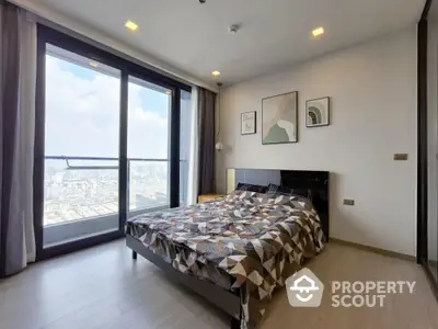 Modern bedroom with large windows and city view, stylish decor and natural light.