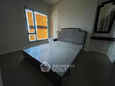 Spacious bedroom with modern bed frame and large window for natural light.