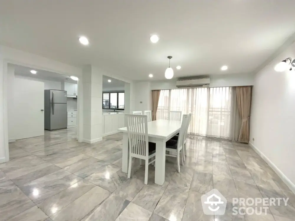 Spacious open-plan dining area with modern kitchen and large windows